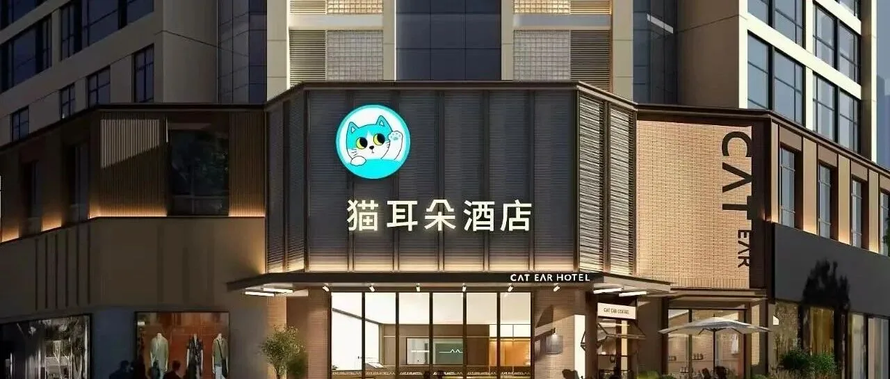 猫耳朵成都旗舰店夜间门头实拍：青猫 IP 头像霓虹招牌搭配「猫耳朵酒店 CAT EAR HOTEL」中英文店招，暖光玻璃入口与竖向格栅外墙